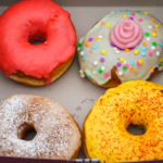 4 colorful vegan donuts in a box