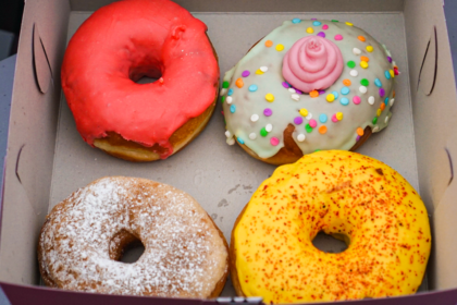 4 colorful vegan donuts in a box