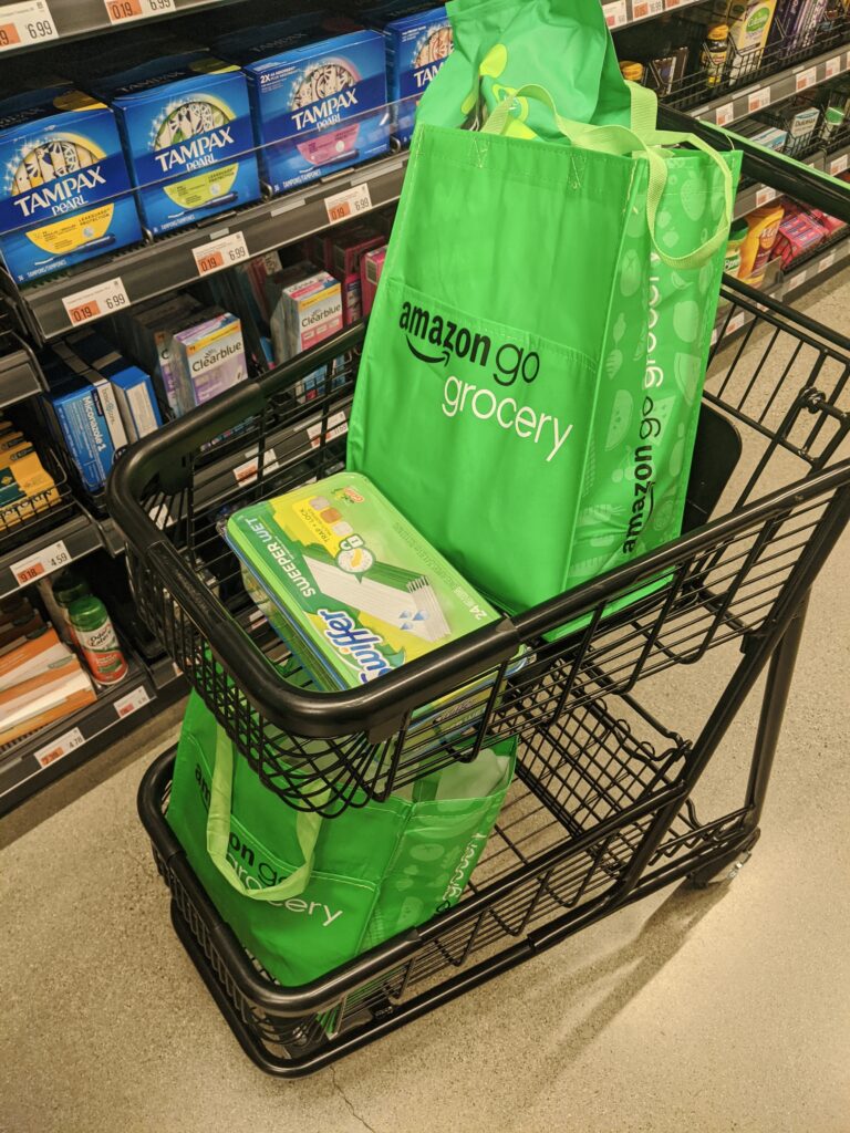 grocery cart with two green amazon go grocery bags
